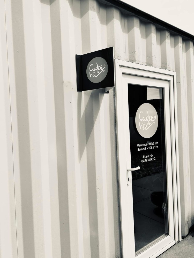 Porte d'entrée de l'atelier avec le logo et les horaires